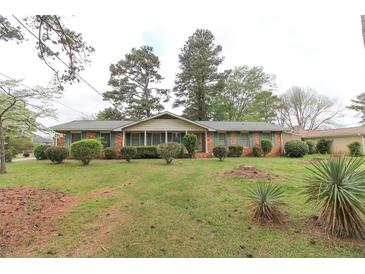 Charming one-story brick home with manicured lawn and mature trees, offering a serene and inviting curb appeal at 3257 Greenvale Way, Decatur, GA 30034