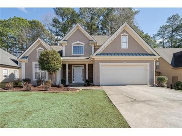 Charming home with a well-manicured lawn, a two-car garage, and a classic stucco facade at 3850 Laurel Nw Dr, Acworth, GA 30101