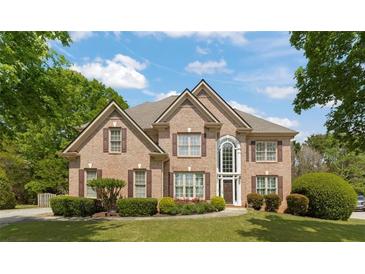 Charming brick two-story home featuring manicured landscaping, a gabled roof, and a grand entryway with large windows at 891 Berryman Pl, Lawrenceville, GA 30045
