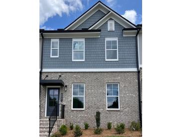 Charming townhome with brick and gray shingle exterior and well-maintained landscaping at 1262 Ainsworth Aly # 48, Sugar Hill, GA 30518