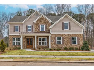 Charming two-story home featuring a blend of brick and siding, well-manicured lawn, and inviting front entrance at 3390 Hillshire Dr, Cumming, GA 30028