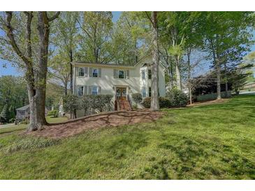 Charming two-story home with a well-manicured lawn, shuttered windows and mature trees at 4540 Saddle Se Ct, Smyrna, GA 30082