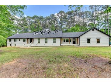 Charming one-story home with manicured lawn, painted brick, dormer windows and natural wood accents at 780 N Ola Rd, Mcdonough, GA 30252
