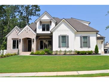 Beautiful two-story home with brick and white siding, lush green lawn, and manicured landscaping at 001 Knob Creek Ct, Acworth, GA 30101