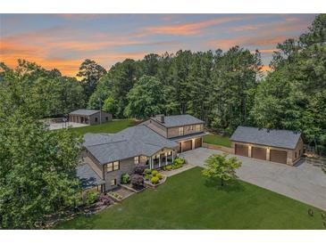 Expansive brick home on a large lot with two outbuildings and lush green landscaping at 204 Mt Moriah Rd, Auburn, GA 30011