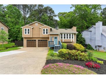 Charming home with a two-car garage, complemented by lovely landscaping and a beautiful garden in the front yard at 4849 Chapelle Ct, Marietta, GA 30066