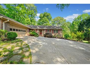 Charming single-story brick home with an attached garage, well-manicured lawn, and plenty of parking space at 659 Pleasant Hill Nw Rd, Conyers, GA 30012