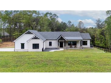 Charming white brick home with black accents, well-manicured lawn and covered porch at 16 Mountain Creek Ne Trl, Fairmount, GA 30139