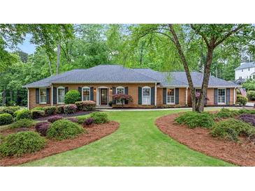 Charming single-story brick home featuring lush landscaping, a well-manicured lawn, and black shutters at 1405 Murdock Rd, Marietta, GA 30062