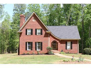 Charming red brick two-story home featuring black shutters, lush lawn, and beautiful landscaping at 349 Harris Loop, Dallas, GA 30157