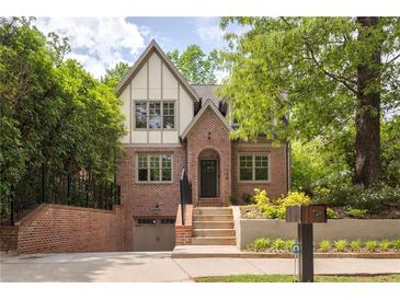 Charming brick two-story home featuring a gable roof, dormer windows, and a nicely landscaped front yard at 134 Woodlawn Ave, Decatur, GA 30030