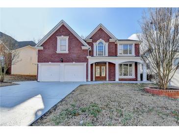 Charming brick home with a well-manicured lawn and a two-car garage, perfect for Gathering living at 1417 Wind Chime Ct, Lawrenceville, GA 30045