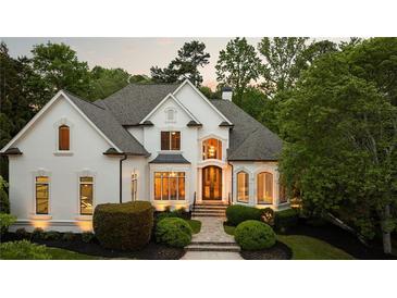 Stunning white home featuring manicured landscaping, arched windows, and a classic design at 5625 Buckleigh Pointe, Suwanee, GA 30024