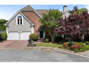 Charming two-story home featuring a brick and stucco exterior, two-car garage, and beautiful landscaping at 4223 Wieuca Overlook Ne, Atlanta, GA 30342