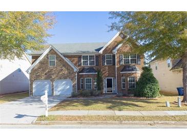 Traditional two-story brick home featuring an attached two-car garage, landscaped yard and mature trees at 6980 Talkeetna Sw Ct, Atlanta, GA 30331