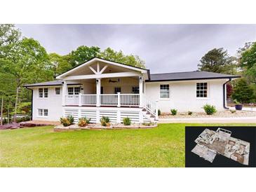 Charming white brick home with a spacious covered porch and manicured lawn at 9680 Ephesus Church Rd, Villa Rica, GA 30180