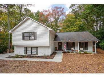 Charming two-story home featuring a white brick and vinyl exterior with a cozy front porch and a well-maintained lawn at 2377 Emory Ln, Marietta, GA 30068