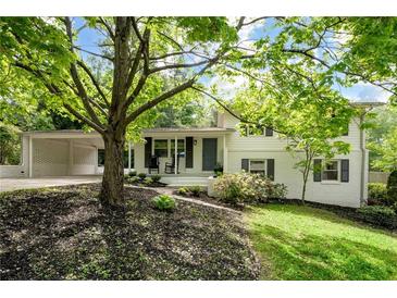 Charming two-story home with white brick, dark shutters, and a covered carport nestled in a tree-filled yard at 3383 Campbell Se Rd, Smyrna, GA 30080