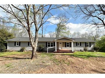 Charming one-story home with gray siding, a covered porch, and a well-maintained front yard at 326 Old Farm Road, Woodstock, GA 30188