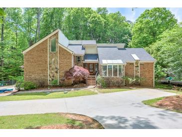 Beautiful brick home featuring a well manicured lawn and concrete driveway at 3493 Wood Acres Blvd, Duluth, GA 30096