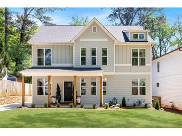 Charming two-story home with light gray siding, black trim, manicured lawn, and welcoming front porch at 2553 Creekwood Ter, Decatur, GA 30030