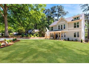 Charming two-story home featuring a lush green lawn and mature trees in a desirable neighborhood at 2553 Creekwood Ter, Decatur, GA 30030