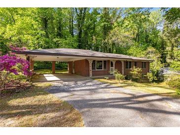 Charming brick home with a covered parking area and lush, mature landscaping in a serene, wooded setting at 470 Hunnicutt Se Rd, Mableton, GA 30126