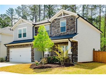 Charming two-story home with a stone facade, well-maintained lawn, and attached two-car garage at 660 Stately Dr, Woodstock, GA 30188
