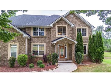 Charming brick home featuring manicured landscaping and a welcoming front entrance at 60 Heritage Keep, Covington, GA 30016