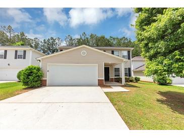 Charming two-story home featuring a well-manicured lawn and an attached two-car garage at 1023 Saint Augustine Pkwy, Locust Grove, GA 30248