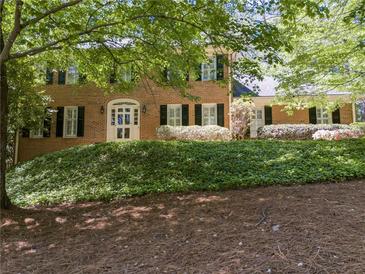 Charming brick home featuring a well-manicured lawn and a classic white-framed arched entryway at 3573 Turtle Cove Se Ct, Marietta, GA 30067