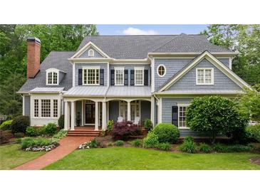 Charming two-story home with blue siding, dark shutters, inviting front porch and lush landscaping at 492 Conway Manor Nw Dr, Atlanta, GA 30327