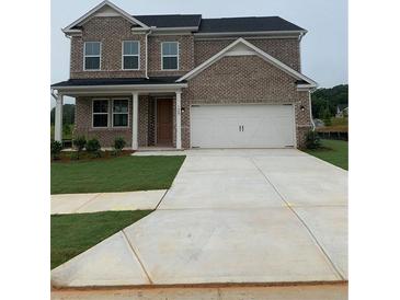 Charming two-story brick home with a manicured lawn and a two-car garage at 126 Kenney Way, Locust Grove, GA 30248