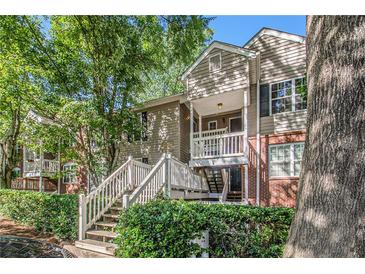 Charming townhome with a brick facade, featuring a private balcony and lush landscaping at 446 Teal Ct, Roswell, GA 30076