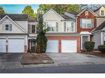 Charming townhome featuring a brick facade, attached garage, and inviting curb appeal at 4208 Royal Regency Nw Cir # 9, Kennesaw, GA 30144