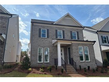Charming gray brick two-story home with manicured lawn and classic architectural details at 146 Birch Tree Way, Cumming, GA 30040