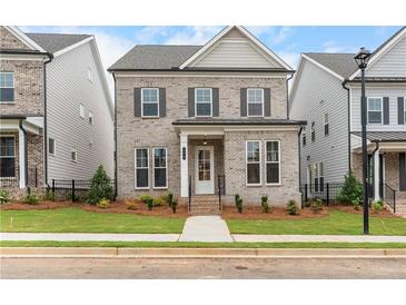 Charming two-story brick home with a well-manicured lawn and classic architectural details at 146 Birch Tree Way, Cumming, GA 30040