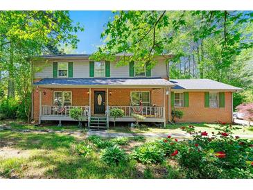 Charming two-story brick home with a welcoming front porch and lush landscaping at 3157 Brooks Dr, Snellville, GA 30078