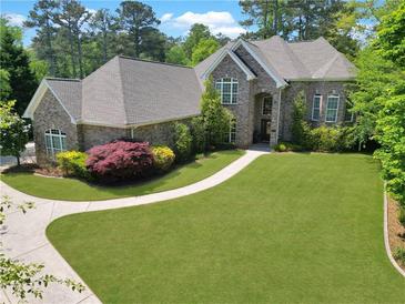 Beautiful brick home showcasing manicured lawn, lush landscaping, and curved driveway at 3590 Fricks Rd, Marietta, GA 30062