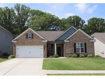 Charming brick home featuring a two-car garage, manicured lawn, and inviting front entrance at 3630 Deaton Trl, Buford, GA 30519