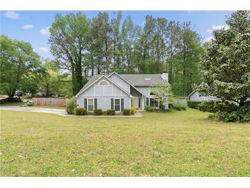 Charming two-story home with manicured lawn, mature trees, and inviting curb appeal at 100 Karla Ct, Roswell, GA 30076