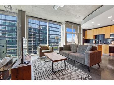 Modern living room featuring large windows and a comfortable seating area with an adjacent kitchen at 923 Peachtree Ne St # 1625, Atlanta, GA 30309