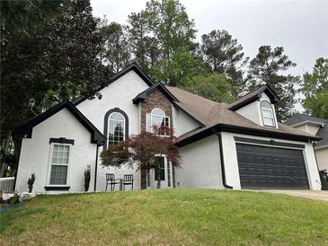 Beautiful home with a well manicured lawn, two car garage, and a combination of brick and painted finishes at 2657 Mcguire Nw Dr, Kennesaw, GA 30144