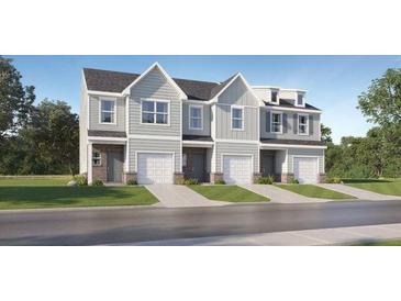 Three-story townhome featuring neutral siding, multi-paned windows, and individual garages and entrances at 229 Kenoot Dr # 49, Mcdonough, GA 30253