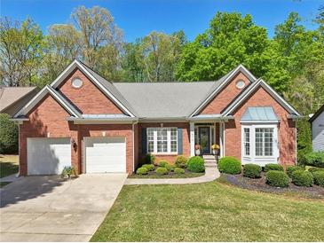 Charming brick home with manicured lawn, two-car garage, and inviting front entrance at 1670 Bookhout Dr, Cumming, GA 30041