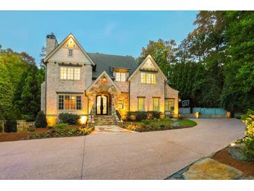 Stunning brick home featuring manicured landscaping and a large driveway at 4140 Hillside Nw Pl, Atlanta, GA 30342