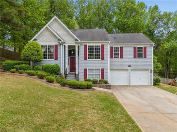 Charming gray split level home with red shutters and well-maintained landscaping at 5525 Tallantworth Trl, Cumming, GA 30040