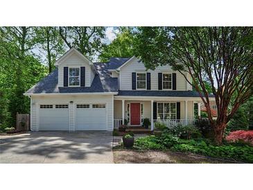 Charming two-story home featuring a well-manicured front yard and a welcoming front porch at 680 Ruxbury Ct, Suwanee, GA 30024