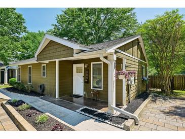 Charming home with a well-manicured lawn, complemented by lush greenery and a cozy front porch with colorful flower baskets at 198 Clay Se St # G, Atlanta, GA 30317