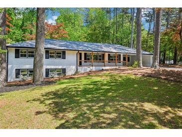 Charming painted brick home featuring a front porch and a beautifully landscaped front yard at 2301 Crestcliff Dr, Tucker, GA 30084